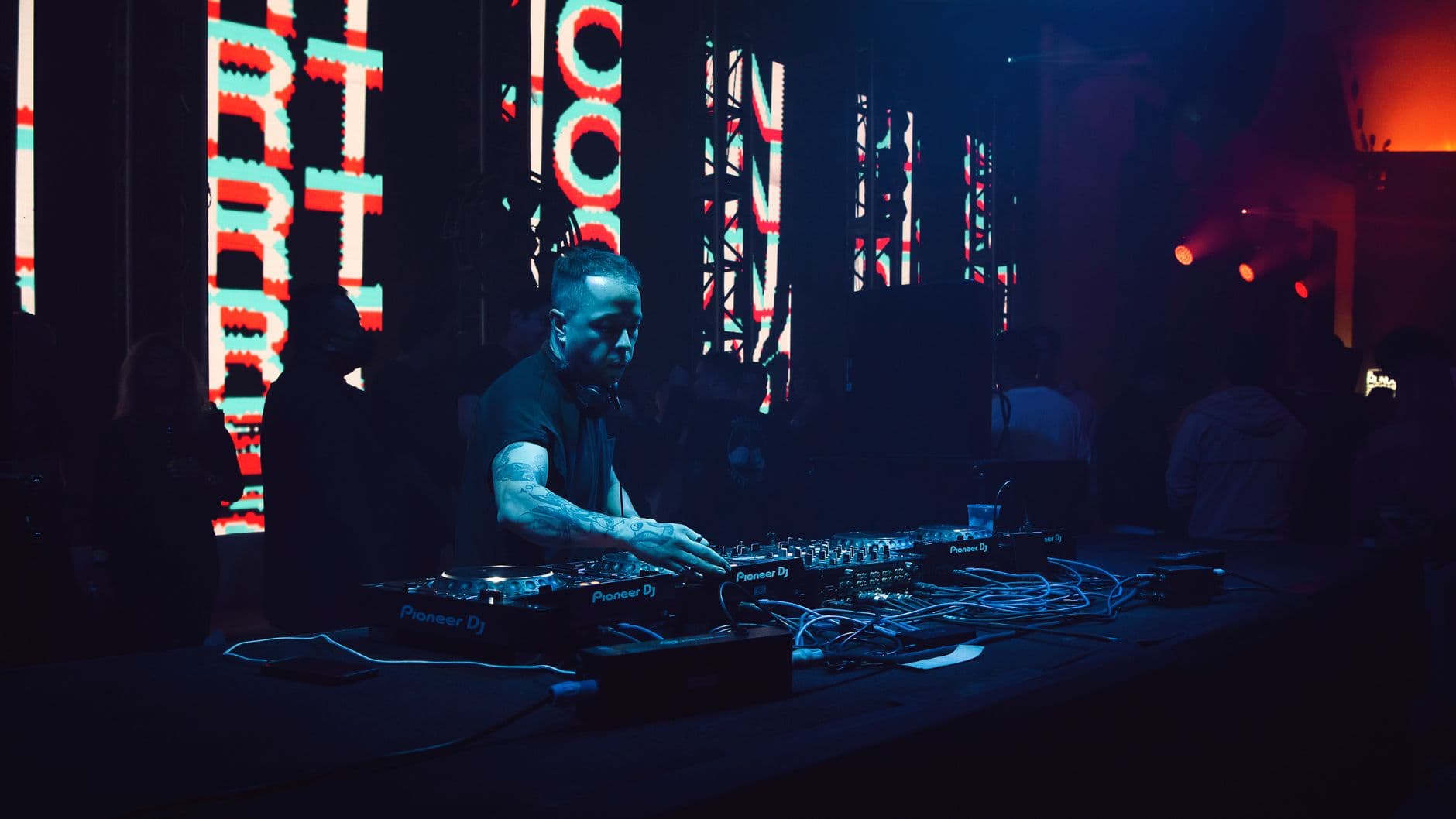 DJ performing at sunset sessions event with stage lighting at Anfiteatro de Marmelete in Algarve