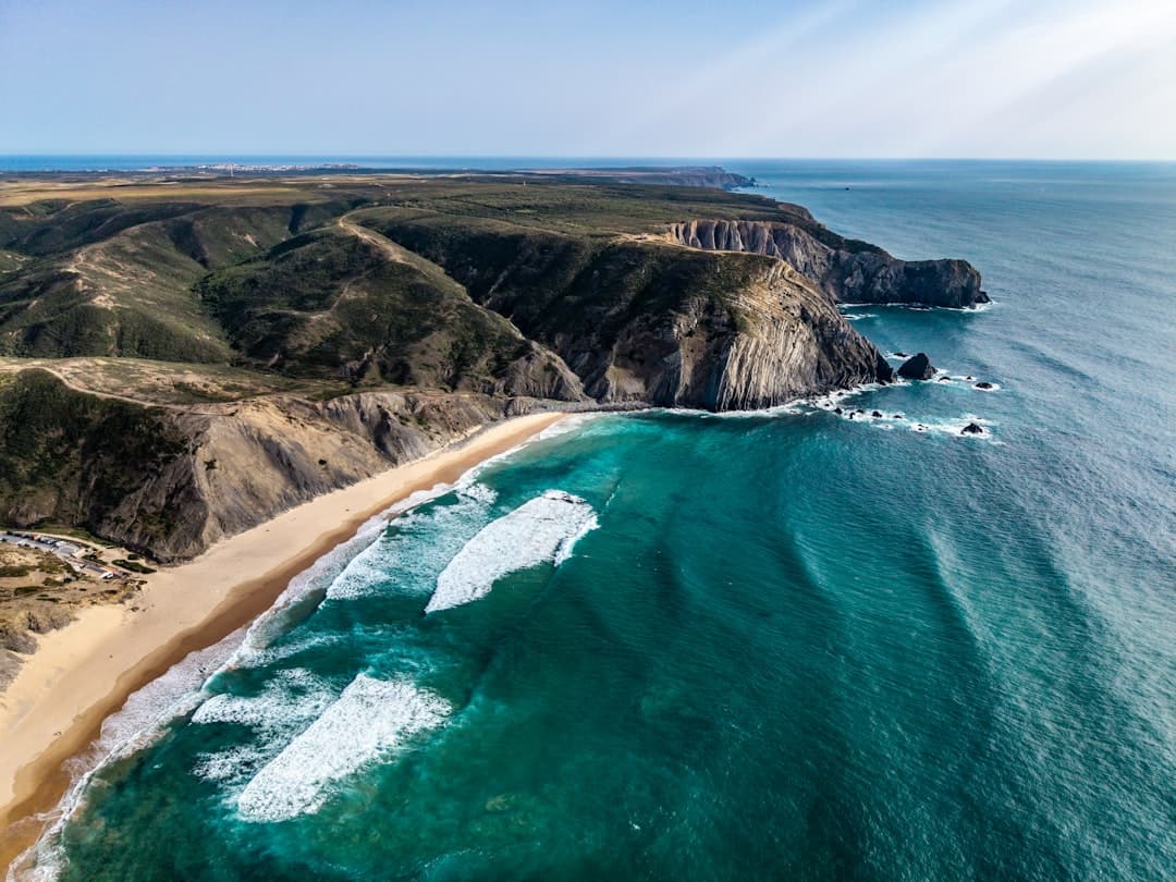 Beautiful sandy beach with crashing waves and rugged coastal cliffs