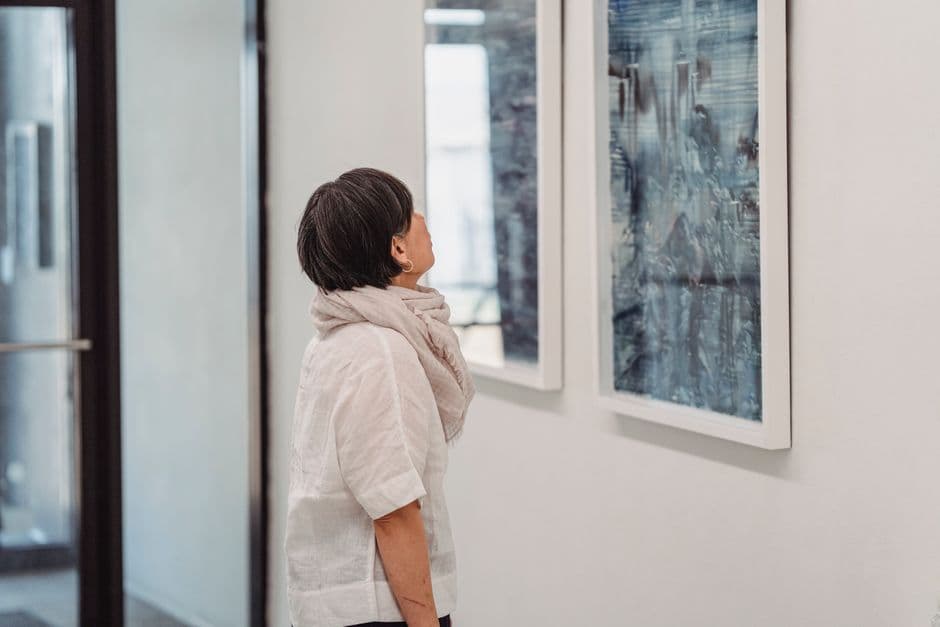 Visitor looking at paintings during the Pepe Gámez art exhibition in Alcoutim, Algarve.