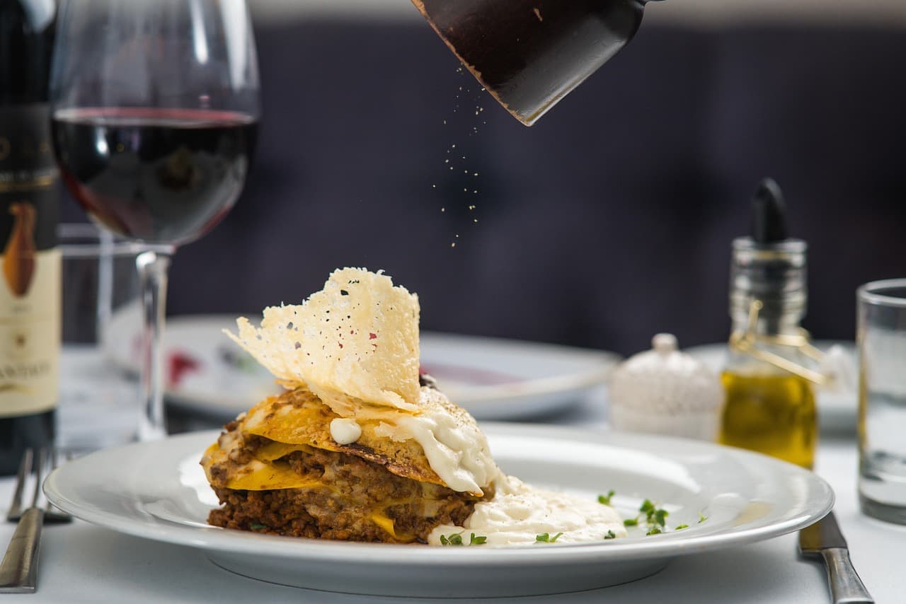 Gourmet dish being seasoned with pepper and red wine at Tribulum restaurant in Faro, Algarve
