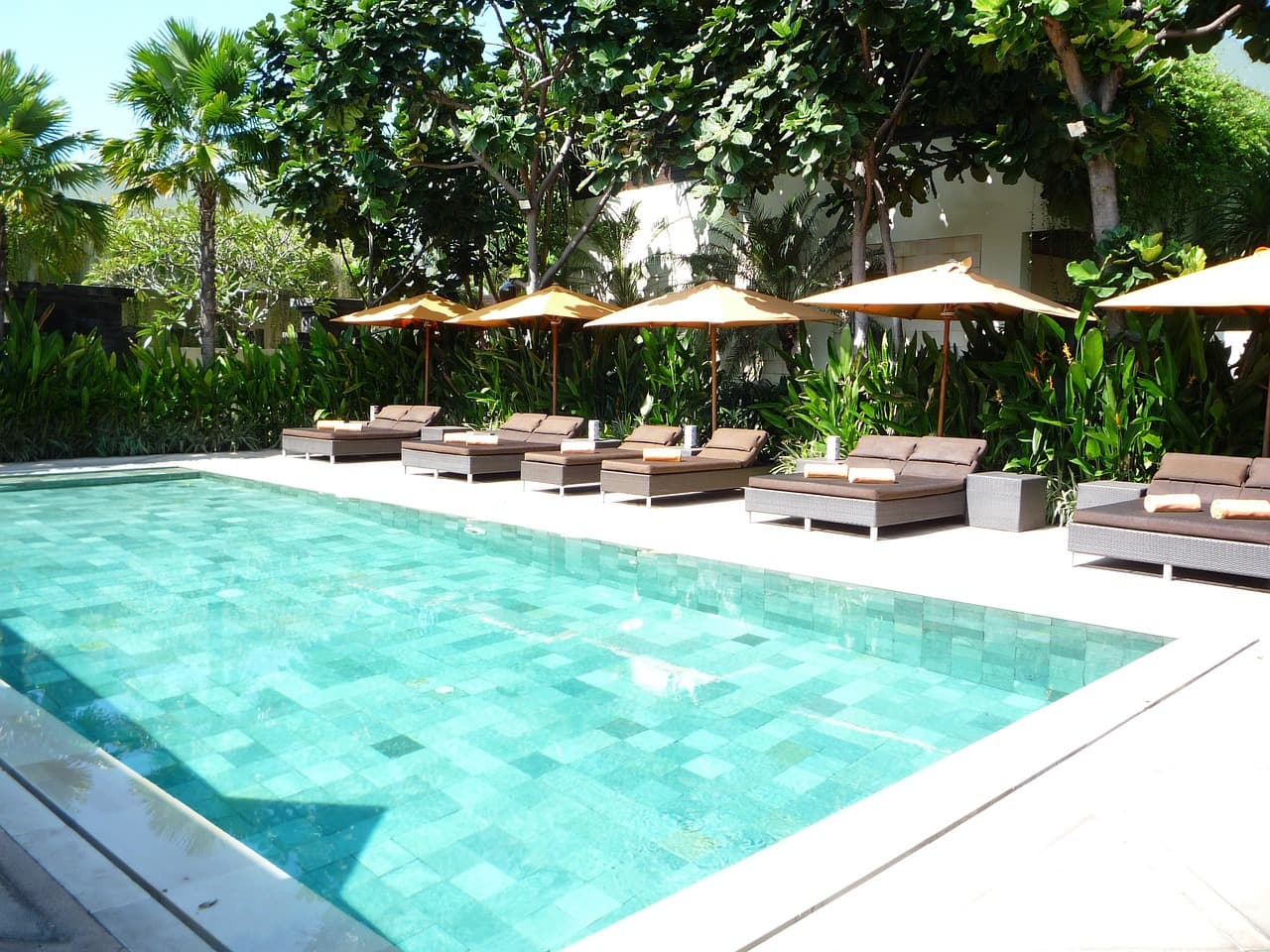 Bali beds and sun loungers by a resort pool at Beach Club Vale do Lobo in Faro, Algarve.