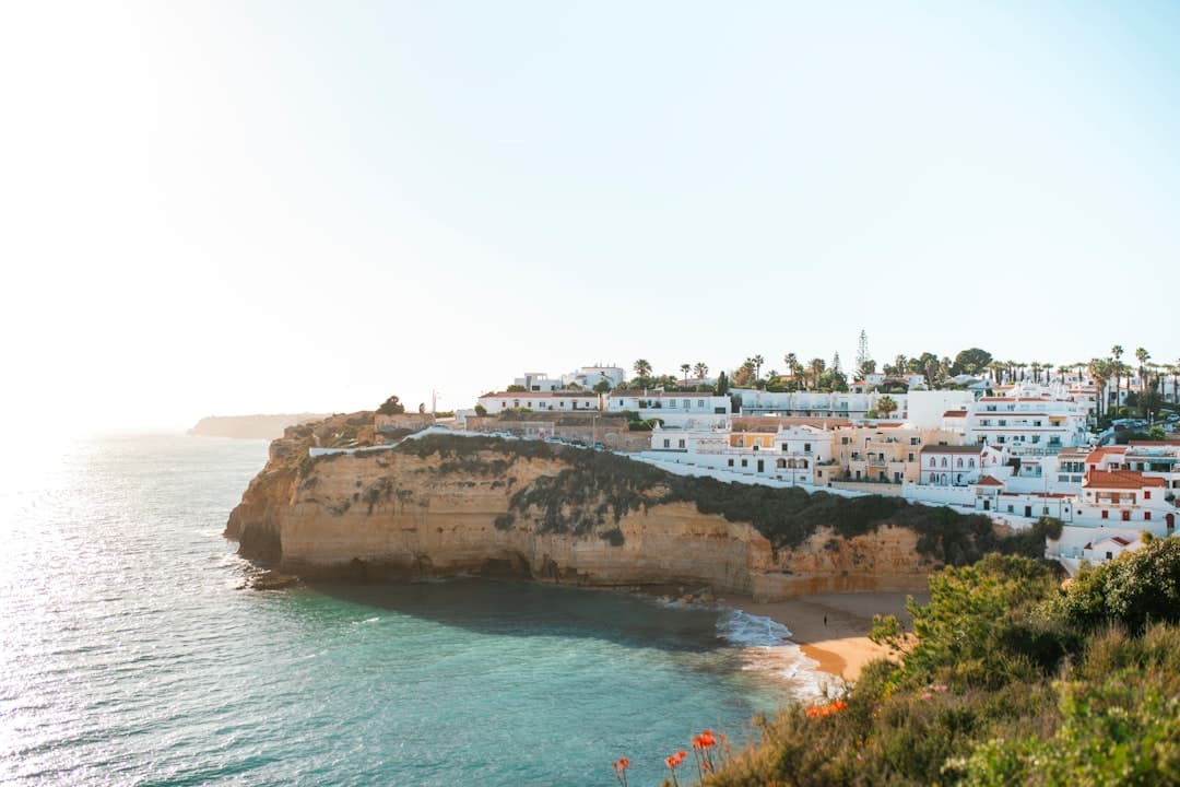 Scenic view of white cliffside buildings overlooking the beach at Praia da Luz in the Algarve, Portugal.