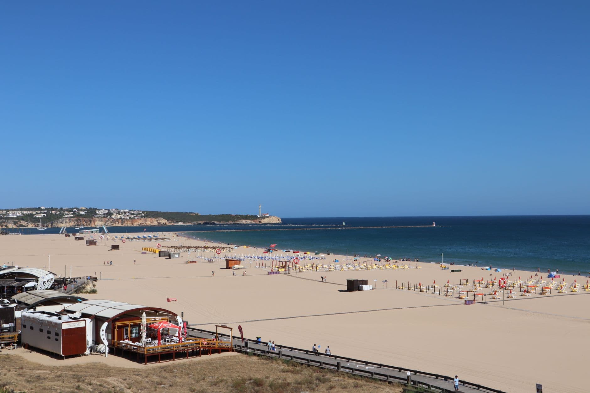 Sunny beach view of NoSoloAgua Portimao in the Algarve, Portugal with sandy shore and calm ocean.
