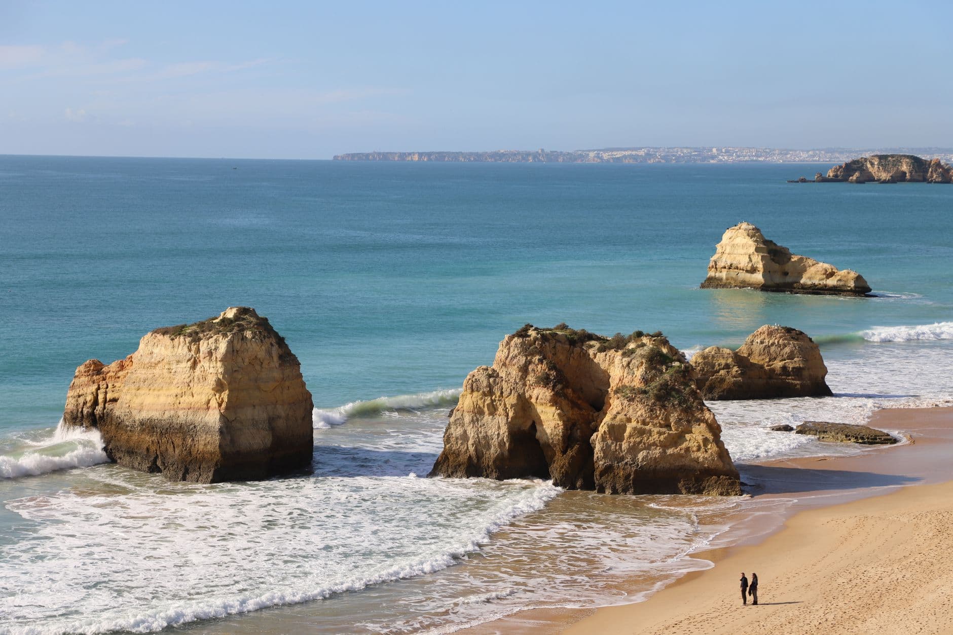 Golden rock formations and sandy beach at Praia da Rocha in Portimão, Algarve, Portugal.