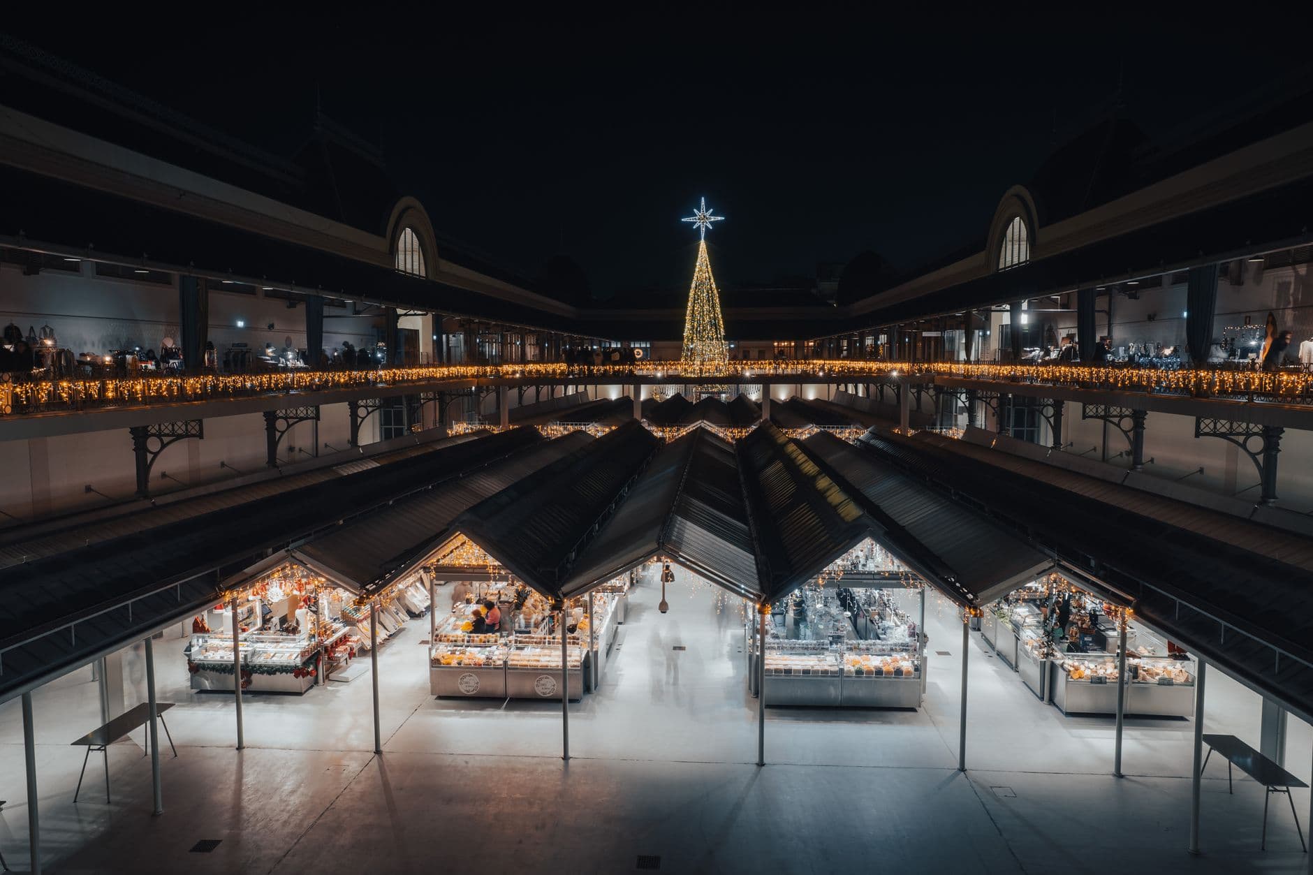 Festive Christmas tree and market stalls illuminated at night inside the Loulé municipal market building in the Algarve.