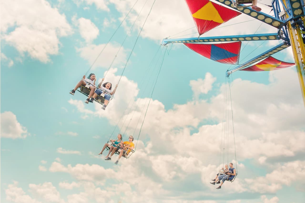 People enjoying swing rides at a fair in Tôr, Loulé, Algarve